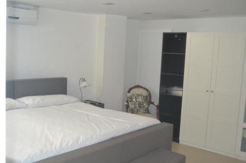 拉普拉亚蒂陶洛Opal Villa de Luxe的卧室配有白色的床和椅子