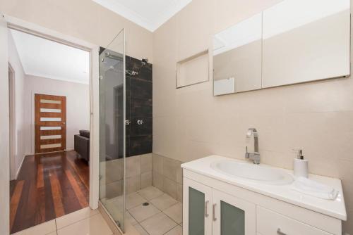 汤斯维尔两卧室小屋民宿的白色的浴室设有水槽和淋浴。