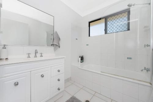 Ross River3 bedroom home的白色的浴室设有浴缸和水槽。