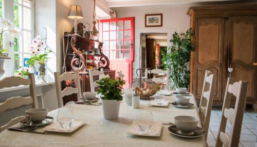 Tréméreuc埃洛伊塞花园住宿加早餐旅馆的桌子上放有盘子和餐具