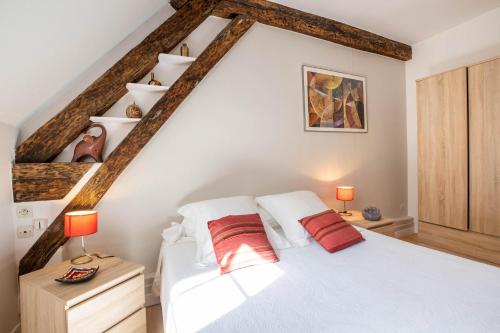 博讷Beaune Sweet Home的卧室配有白色床和2个红色枕头