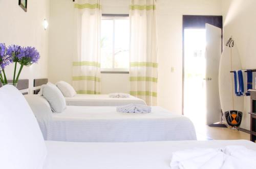 埃斯孔迪多港齐卡特拉简易别墅酒店的带窗户的客房内的2张白色床