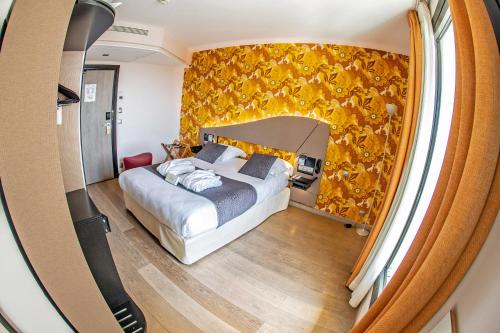 巴黎Hôtel Hor Europe的一间卧室设有一张床和黄色的墙壁