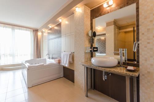 豪伊杜索博斯洛匈格特阿波罗酒店的带浴缸、水槽和浴缸的浴室