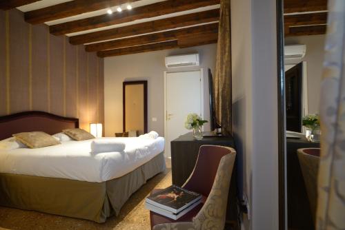 威尼斯凤凰公寓式酒店的配有一张床和一把椅子的酒店客房
