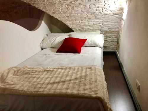 鲁沃迪普利亚L'Orecchietta的一张小床,上面有红色枕头
