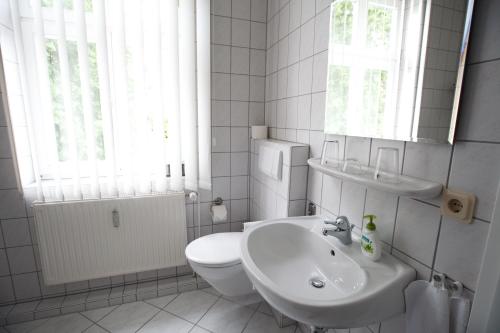 Kalbe“祖姆普特库臣”兰德酒店的白色的浴室设有卫生间和水槽。