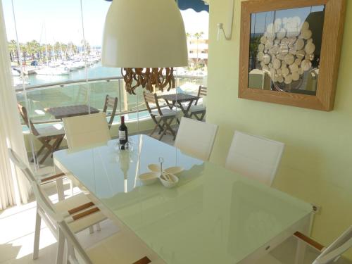 贝纳尔马德纳Benalmadena Costa Sol Holiday Rentals的一间设有白色桌椅和窗户的用餐室