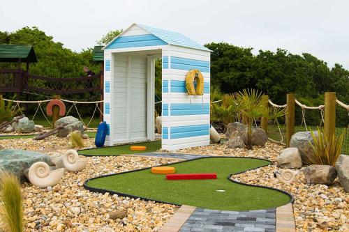 本布里奇Whitecliff Bay Holiday Park的花园中的一个小游戏房,设有迷你高尔夫球场