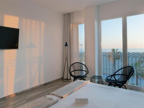 瓦伦西亚巴兰德莱特精品酒店 的一间卧室配有一张床铺和椅子,设有一个阳台