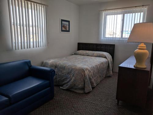 怀尔德伍德Tide Winds Motel的一间卧室配有一张床、一把椅子和一盏灯