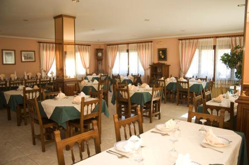 QuintanillaPosada Rural Peñasagra的用餐室配有桌椅和绿色餐巾
