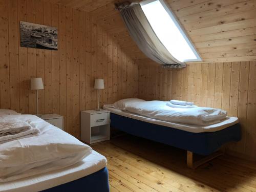 Gjesvær诺德卡普菲瑞公寓的一间卧室设有两张床,其中设有窗户。