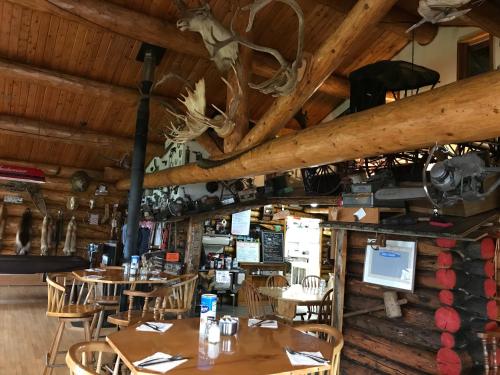 格伦纳伦Lake Louise Lodge, Alaska的餐厅设有桌椅和木制天花板。