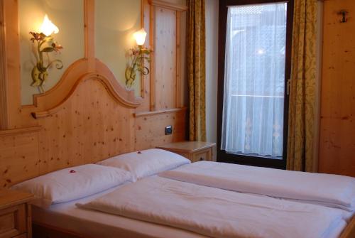 塞斯托Hotel Loewenwirt的卧室设有两张床,带窗户