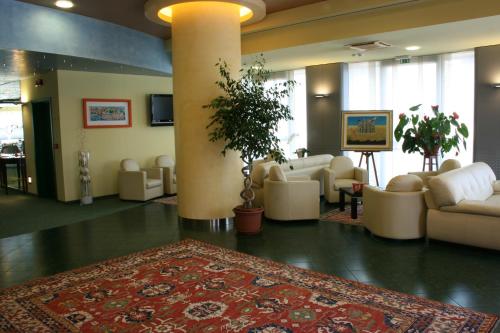戈尔贡佐拉瑟纳特酒店的大堂配有白色家具和地毯