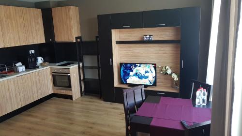 索非亚Apartments Mladost 1A的一间厨房,内设桌子和一台电视机