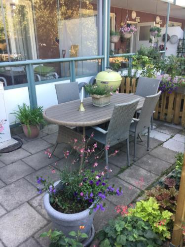 斯德哥尔摩Farsta Bed and Breakfast的庭院配有桌椅和鲜花