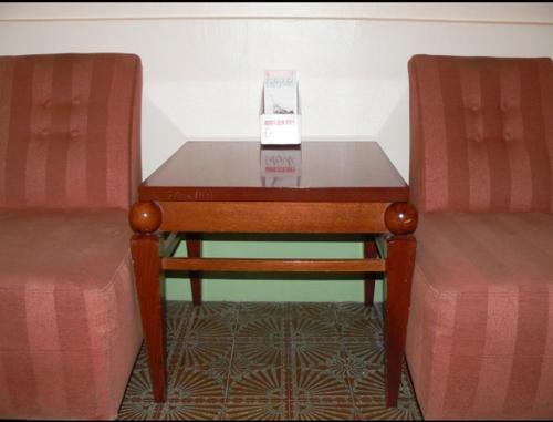巴黎布拉邦酒店的一张桌子,上面有盒子,旁边是两把椅子