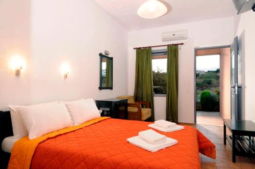 LivadiPetradi的一间卧室配有一张带橙色毯子的床