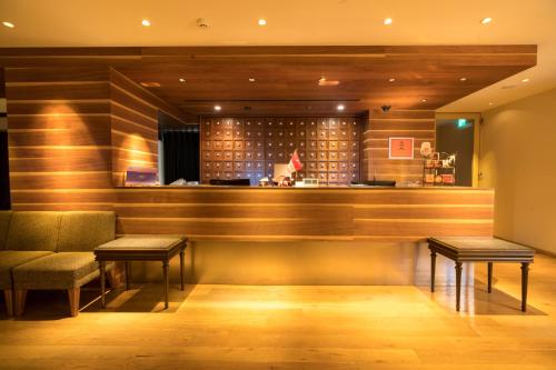 松本松本丸之内酒店的餐厅内的酒吧设有两张桌子和长凳