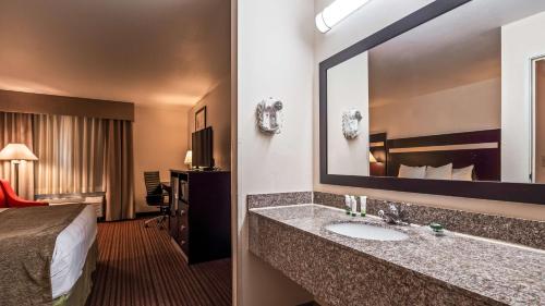 ParsonsBest Western Parsons Inn的酒店客房设有一张床和一间带水槽的浴室