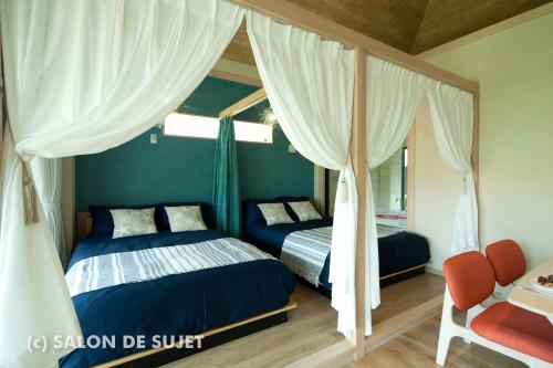 名户Bougain Terrace Resort Ta-chi House的一间卧室设有两张床和天篷