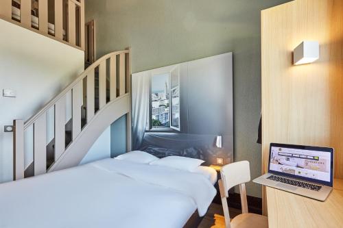 阿夫勒尔B&B HOTEL Le Havre Harfleur 1的一间卧室配有两张床和一张桌子上的笔记本电脑