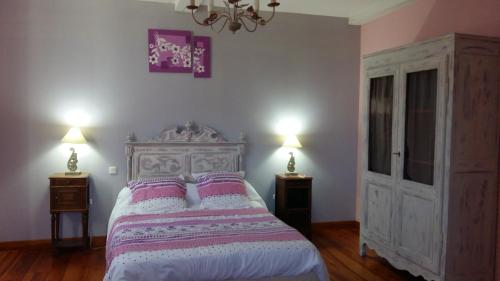 Audignon拉尔雷住宿加早餐旅馆的一间卧室配有一张带2个床头柜和2盏灯的床。