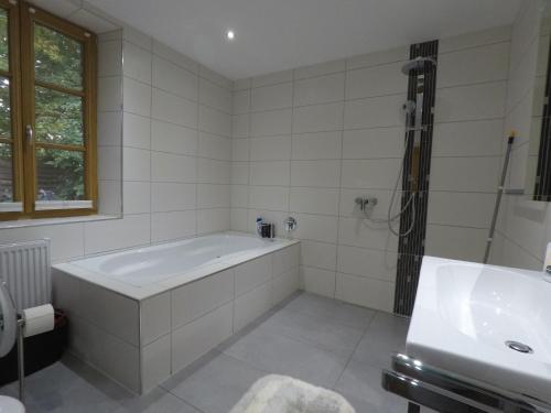 格雷弗拉特Ferienwohnung auf dem Sturmhof的白色的浴室设有浴缸和水槽。