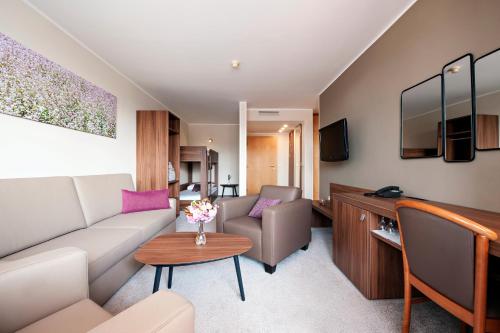 摩拉瓦托普利采阿扎酒店 - 泰尔梅3000 - 萨瓦酒店及度假村 的客厅配有沙发和桌子