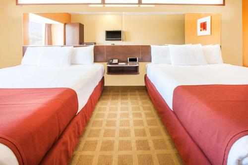斯蒂尔沃特Microtel Inn by Wyndham Stillwater的一间酒店客房,设有两张床和电视