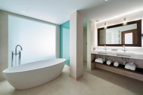 巴塞罗那科隆巴塞罗那酒店的一间带大型白色浴缸和镜子的浴室