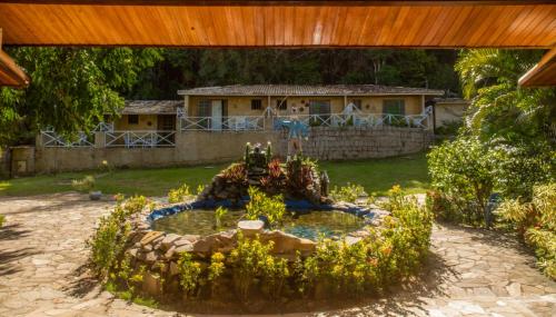巴拉多库努Pousada do Forte的一座花园,房子前面有一个喷泉