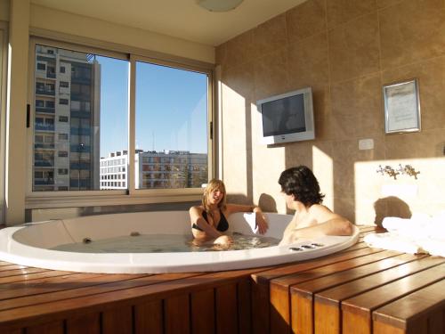 门多萨维拉吉奥精品酒店的两个女人坐在带窗户的浴缸里