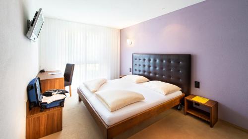 迈恩费尔德瑞士海蒂酒店的一间卧室配有一张大床和电视