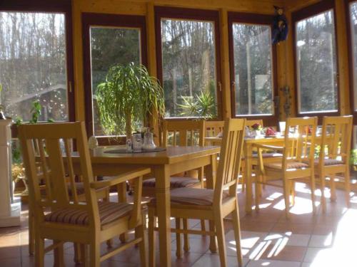 巴特司塔福斯坦Pension Haus am Heubach的一间带桌椅和窗户的用餐室