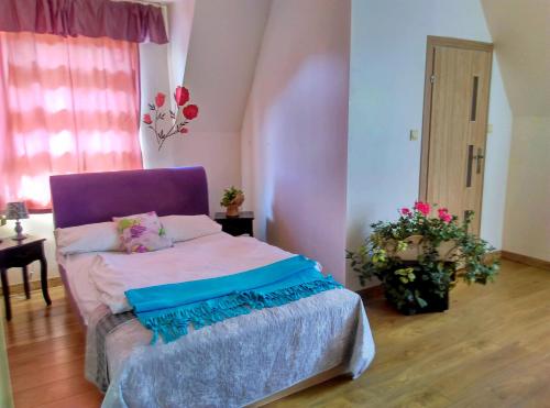 弗罗茨瓦夫Motel Rezydent的一间卧室配有一张带紫色床头板的床