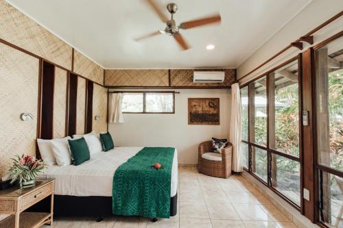 Maninoa辛纳雷礁水疗度假酒店的一间卧室配有一张床和吊扇