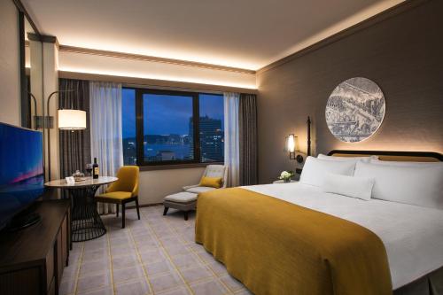 澳门澳门雅辰酒店的酒店客房配有一张床、一张书桌和一台电视。