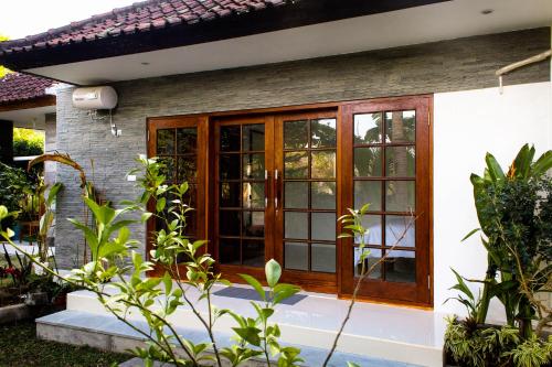 努沙杜瓦Pier26 Bali Homestay的一座带木门和窗户的房子