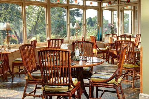 梅尔顿莫布雷西松拜诺尔贝斯特韦斯特酒店的餐厅设有木桌、椅子和窗户。