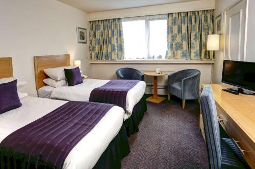 弗罗德舍姆Best Western Frodsham Forest Hills Hotel的酒店客房设有两张床和一台平面电视。