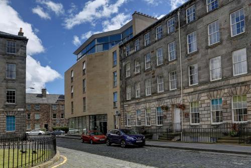 爱丁堡Ten Hill Place的两辆车停在大楼前的建筑物