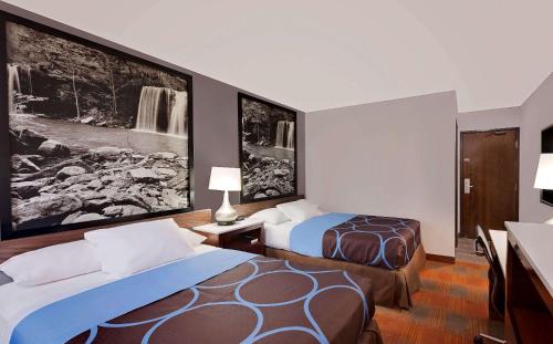 费耶特维尔菲耶特维尔速8酒店的酒店客房设有两张床,墙上挂有绘画作品
