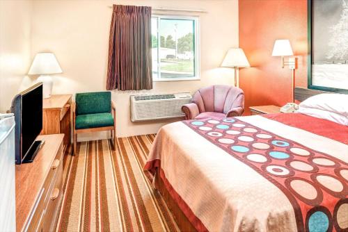 Blair布莱尔速8酒店的酒店客房配有一张床、一张桌子和一把椅子。