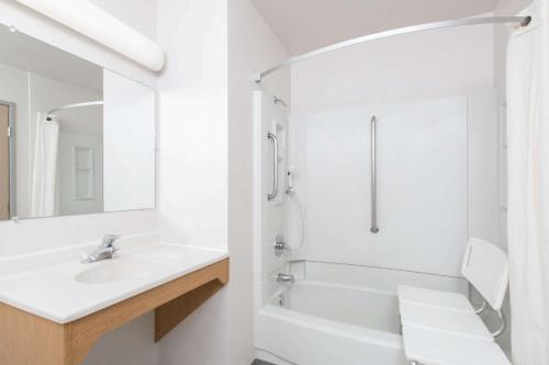 克奇坎Super 8 by Wyndham Ketchikan的白色的浴室设有水槽和浴缸。