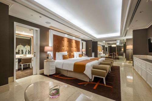 马尼拉Okada Manila的酒店客房设有一张大床和一张书桌。