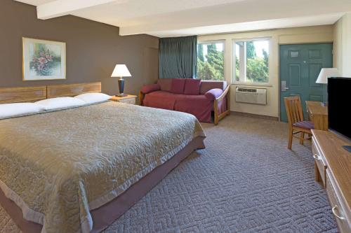 科斯塔梅萨Costa Mesa Inn - Newport Beach Area的酒店客房,配有床和沙发
