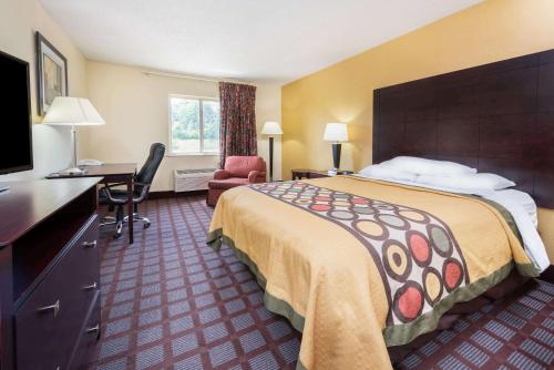布卢明顿Super 8 by Wyndham Bloomington University Area的酒店客房设有一张大床和一张书桌。